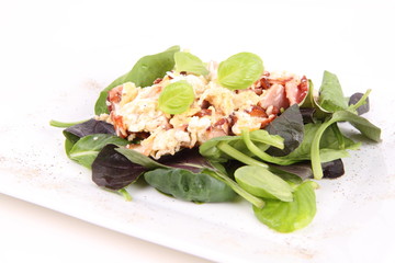 Scrambled eggs with ham on spinach