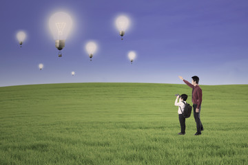Businessman generation looking at lightbulbs outdoor