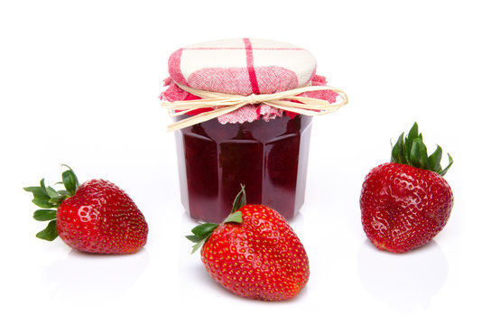 Jar of strawberry jam with fresh strawberries