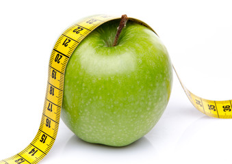 Measuring tape on a green apple
