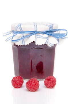 Jar of raspberry jam with fresh raspberries
