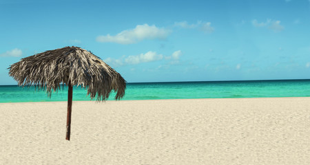 Fototapeta na wymiar Egzotycznych plaża z palmy parasol, lazurowe morze i błękitne niebo