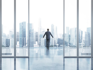 Fototapeta premium Businessman standing on a balcony and looking at city