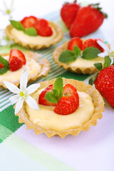 Tasty tartlets with strawberries on table close-up