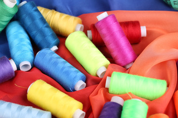 Multicolor sewing threads on color fabric background