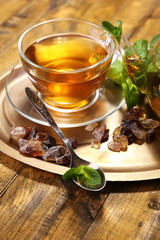 Composition of fresh mint tea in glass cup and teapot