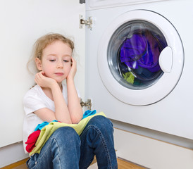 Little girl doing laundry. Housework concept.