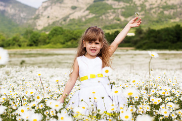 Cute child girl at camomile field