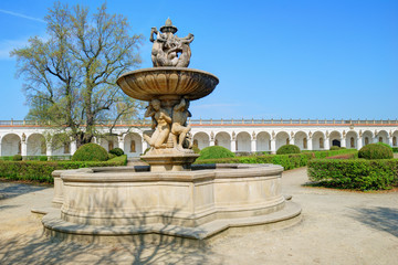 Historic fountain and long white colonnade in the background