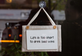 Small sign on a wine shop window saying "Life is too short to dr