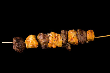 Tasty skewers on black background.