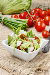 Bowl of fresh salad on wooden table