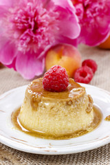Creme caramel and beautiful pink peonies in the background