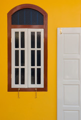 A vintage door and window on yellow wall