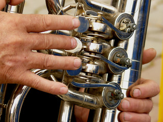 fragment of tuba with hands of musician