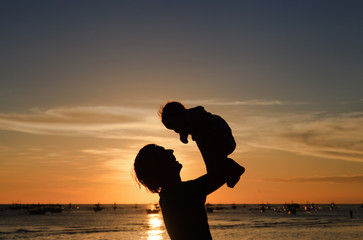 Fototapeta premium father and daughter silhuettes on sunset beach
