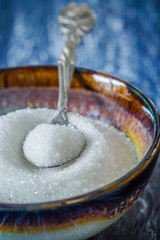 the brown sugar in silver spoon on wooden background