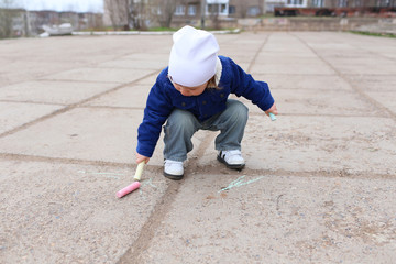 baby painting with chalk outdoors