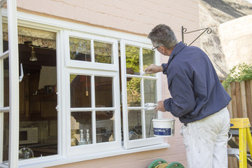 Painter painting the windows of a house