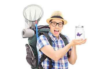 Male hiker holding a butterfly in a jar