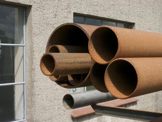 Rostige alte Rohre mit unterschiedlichem Durchmesser vor einer alten Werkstatt in Wellentrup und...