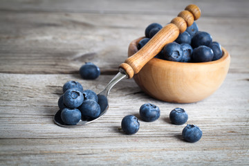 bowl of blueberries on wooden background