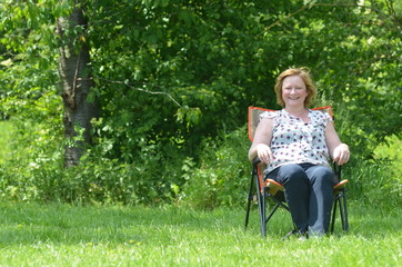 Fototapeta premium woman in camping chair in field