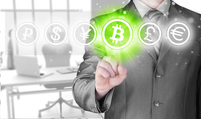Choosing bitcoins, businessman pressing touch screen button.
