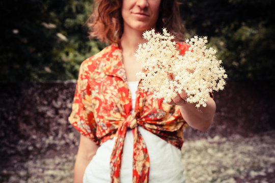 Young woman holding a bunch of elderflowers