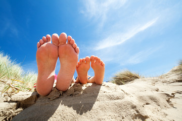 Relaxing feet on the beach - obrazy, fototapety, plakaty