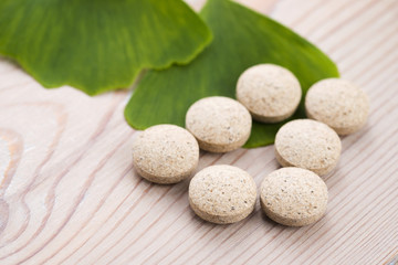 Ginkgo biloba leaves in mortar and pills
