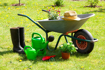 Gardening tools and a straw hat on the grass in the garden