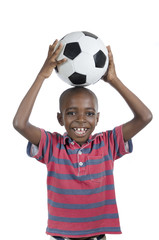 Afrikanischer Junge mit Fussball lächelt