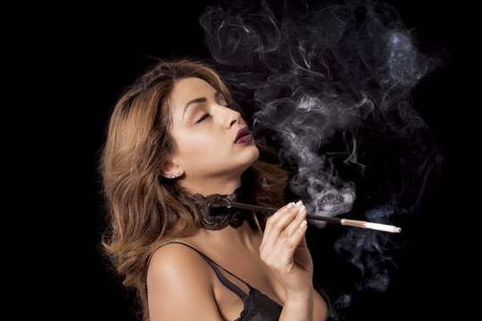 Sexy woman with cigarette holder smoking