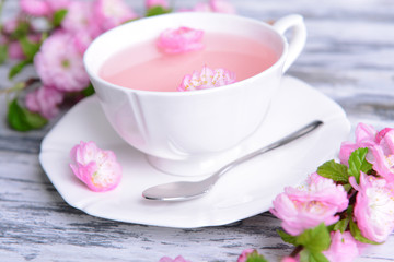 Beautiful fruit blossom with cup of tea on table close-up
