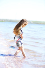 Naklejka premium Beautiful little girl on the beach