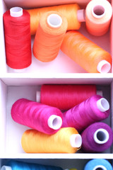 Multicolor sewing thread in wooden box, close-up