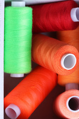 Fototapeta na wymiar Multicolor sewing thread in wooden box, close-up