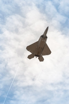 military stealth fighter silhouette against a cloudy sky
