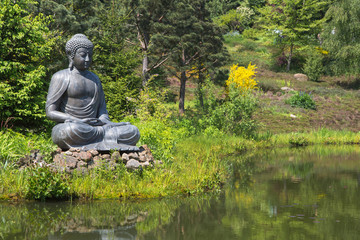 Buddha Figur im Garten am Teich als Dekoration