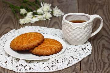 Baked cookies with tea and flowers.