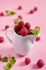 Ripe raspberries on pink background