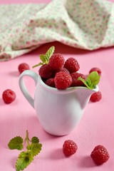 Ripe raspberries in a white jug