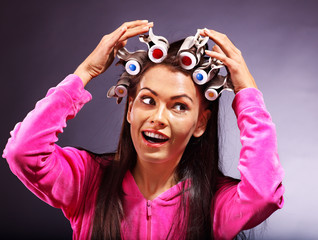 Woman wear hair curlers on head.