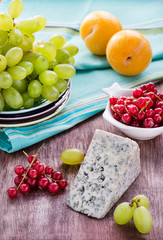 Blue cheese with fruits on wooden background