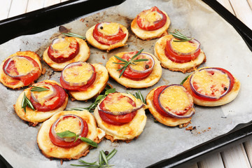 Small pizzas on baking paper close up