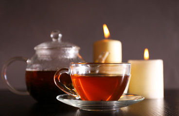Composition with tea in glass teapot and candles