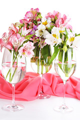 Freesias in glasses on table close-up