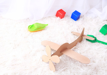 Paper airplane toy in room on the carpet