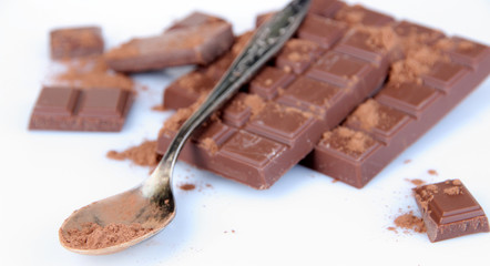 Cocoa powder and dark chocolate isolated on white